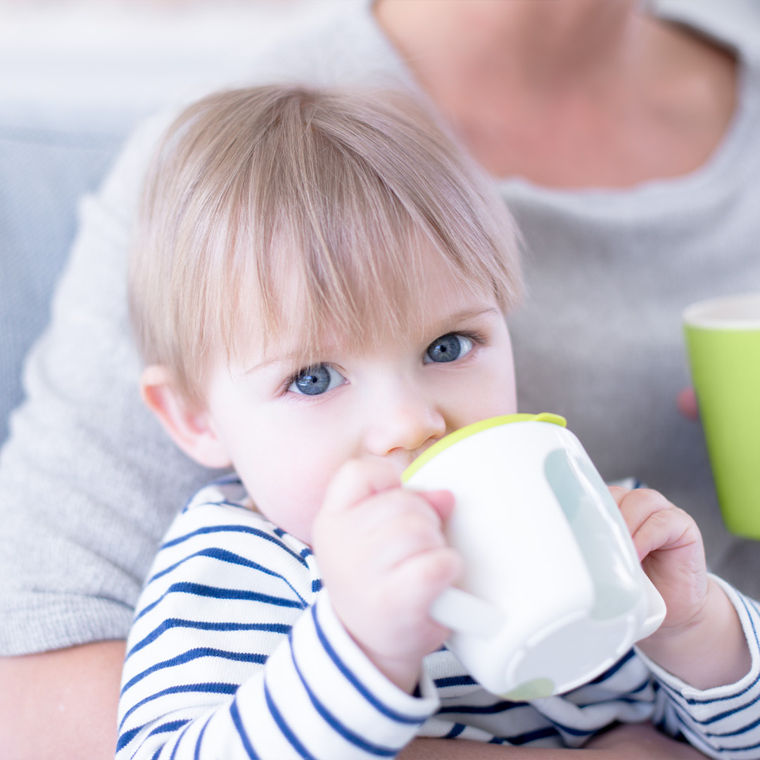 Banner baby drinking from sippy cup