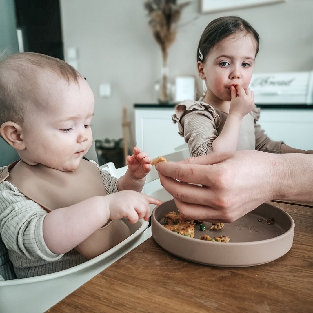 Siblings eating at table