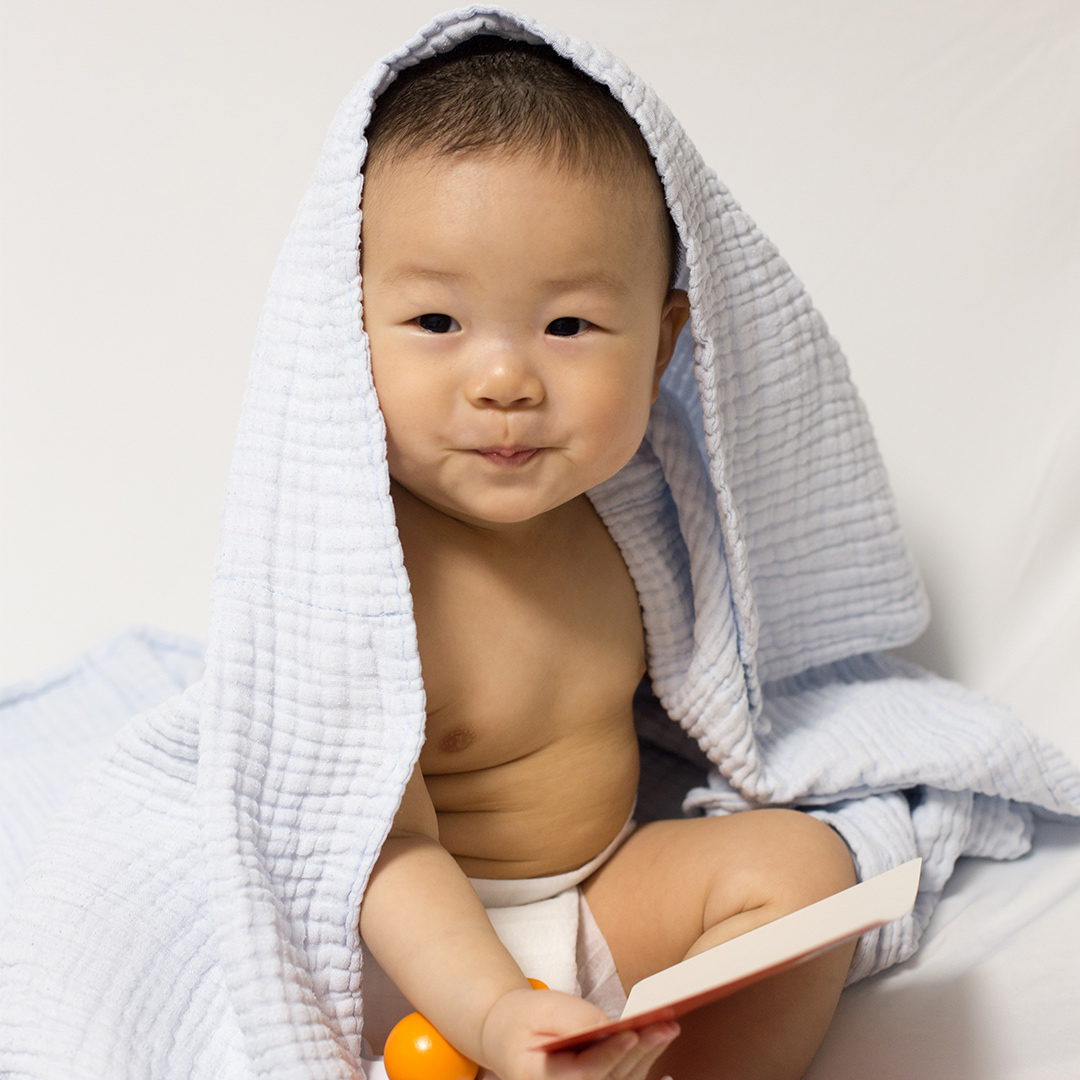 baby sitting under blanket