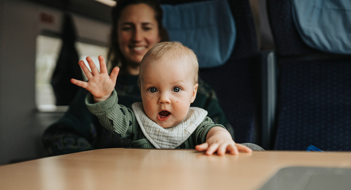 Baby waving in moms lap
